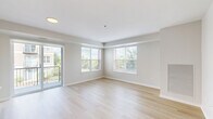 Located at 450 Warrenville Rd in Lisle, IL, this well-appointed two-bedroom, two-bathroom residence offers a thoughtfully designed single-floor layout. Light hardwood flooring flows throughout the main living areas, complementing a clean, neutral color palette that creates a bright and airy atmosphere.

The open-concept living, dining, and kitchen area serves as the heart of the home. The kitchen is a standout feature, boasting rich dark-wood cabinetry, a herringbone-pattern tile backsplash, stainless steel appliances including a range, microwave, and refrigerator, and a large island with a quartz countertop and undermount sink. Pendant lighting adds a polished finishing touch. The spacious living area is bathed in natural light from multiple windows and provides direct access to a private balcony overlooking lush outdoor greenery.

Both bedrooms are finished with plush carpeting and include closet storage. The generously sized primary bedroom offers a comfortable retreat. The secondary bedroom is equally well-proportioned. Both bathrooms are finished with tile flooring, dark-wood vanities, white countertops, and a tub-shower combination. Additional conveniences include an in-unit laundry area, an entrance foyer with a louvered closet door, and ample overall storage throughout.