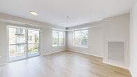 Located at 450 Warrenville Rd in Lisle, IL, this well-appointed two-bedroom, two-bathroom residence offers a thoughtfully designed single-floor layout. Light hardwood flooring flows throughout the main living areas, complementing a clean, neutral color palette that creates a bright and airy atmosphere.

The open-concept living, dining, and kitchen area serves as the heart of the home. The kitchen is a standout feature, boasting rich dark-wood cabinetry, a herringbone-pattern tile backsplash, stainless steel appliances including a range, microwave, and refrigerator, and a large island with a quartz countertop and undermount sink. Pendant lighting adds a polished finishing touch. The spacious living area is bathed in natural light from multiple windows and provides direct access to a private balcony overlooking lush outdoor greenery.

Both bedrooms are finished with plush carpeting and include closet storage. The generously sized primary bedroom offers a comfortable retreat. The secondary bedroom is equally well-proportioned. Both bathrooms are finished with tile flooring, dark-wood vanities, white countertops, and a tub-shower combination. Additional conveniences include an in-unit laundry area, an entrance foyer with a louvered closet door, and ample overall storage throughout.