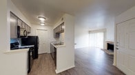 Located at 2626 Thousand Oaks Dr in San Antonio, TX, this single-floor unit offers a thoughtfully designed layout with a comfortable, functional flow throughout. The living area is a standout space, showcasing rich hardwood-style flooring, crisp white walls, and a classic brick fireplace that serves as a focal point. A large sliding glass door floods the room with natural light and provides direct access to an outdoor area, enhancing the sense of openness. The kitchen is designed for efficiency, featuring a galley-style layout with gray cabinetry, granite-look countertops, a mosaic tile backsplash, and black appliances including a refrigerator, range, and dishwasher. A pass-through window with a granite-topped bar counter connects the kitchen to the living and dining areas, creating an open and social atmosphere. A pendant light fixture adds a refined touch to the dining space. The bedroom offers plush carpeting and a clean, neutral palette, providing a calm retreat. The bathroom includes a full soaking tub and shower combination with white tile surround and chrome fixtures. Throughout the unit, consistent hardwood-style flooring, ample cabinet storage, and a neutral color scheme create a cohesive and move-in-ready environment.