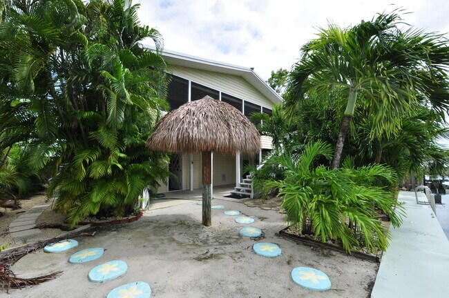 Fenced back yard with tropical foliage and 50 feet of concrete dock - 3978 Gordon Rd
