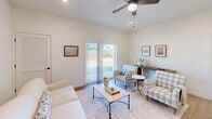 Located at 5543 E NC 150 Hwy in Maiden, NC, this single-floor, 2-bedroom, 2-bathroom home offers a thoughtfully designed layout that maximizes functionality and comfort. The open-concept living and kitchen area serves as the heart of the home, bathed in natural light streaming through a sliding glass door that opens to an outdoor view. The living room features a ceiling fan, neutral walls, and warm hardwood-style flooring, creating an inviting and airy atmosphere. The kitchen is a standout feature, boasting a large white quartz peninsula with seating for four, dark espresso cabinetry, stainless steel appliances including a refrigerator, range, and microwave, and elegant pendant lighting overhead. Both bedrooms are generously sized with plush carpeting, ceiling fans, and windows that bring in natural light. The spacious primary bedroom includes a walk-in closet and an en-suite bathroom with a quartz vanity and gray cabinetry. The second bedroom offers a double-door closet and easy access to the second full bathroom, which features a classic tub-shower combination. Clean white walls, modern hardware, and consistent finishes throughout give this home a cohesive, move-in-ready appeal.