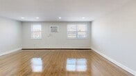 Located at 1008 E Lycoming St in Philadelphia's 19124 neighborhood, this well-appointed one-bedroom, one-bathroom unit offers a thoughtfully designed layout across a single floor. Gleaming hardwood floors run throughout the main living areas, reflecting natural light that pours in through multiple windows fitted with blinds. The open-concept kitchen and living room serve as the heart of the unit, highlighted by a striking blue-paneled kitchen island topped with a crisp white countertop. The kitchen is further elevated by white cabinetry, a bold blue hexagonal tile backsplash, stainless steel appliances including a gas range and microwave, and a trio of gold pendant lights overhead. Recessed lighting adds to the bright, clean ambiance. A stacked washer and dryer is conveniently accessible within the unit. The bedroom offers comfortable carpeted flooring, a ceiling fan, a window unit air conditioner, baseboard heating, and a set of sliding closet doors providing generous storage. The bathroom features a tub-shower combination with textured white tile surround, a gray vanity, and light tile flooring. Throughout the unit, neutral gray-white walls and clean white trim create a cohesive, modern aesthetic.