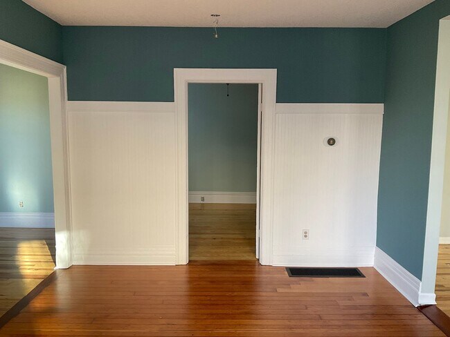 Vista de la sala de estar y del dormitorio de la planta baja desde el comedor. - 3915 NE Rodney Ave