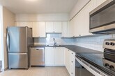 Located at 2770 Aquitaine Ave in Mississauga, Ontario, this 2-bedroom, 1-bathroom unit offers a clean, modern aesthetic throughout. The open-concept kitchen and living area form the heart of the space, with the kitchen showcasing white shaker-style cabinetry, a classic subway tile backsplash, light tile flooring, and a full suite of stainless steel appliances including a refrigerator, electric range, and over-the-range microwave. The living room extends generously from the kitchen and is finished with warm wood-tone laminate flooring, neutral wall tones, and a large window that fills the space with natural light. A sliding glass door provides access to a private balcony with outdoor views. Both bedrooms feature the same durable laminate flooring and bright windows overlooking the surrounding area. The primary bedroom is a comfortable size, offering direct access to a dedicated closet fitted with sliding white panel doors. The second bedroom is equally well-lit and versatile. The four-piece bathroom is finished with light tile flooring, a tiled tub-surround with accent strip detailing, a vanity with dark countertop, white cabinetry, and a mirrored medicine cabinet above. The unit presents a cohesive, move-in ready living environment throughout.