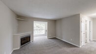 Located at 1720 Old St. Marks Church Rd in Burlington, NC, this single-floor, 2-bedroom, 2-bathroom home offers a well-organized layout with comfortable living spaces throughout. The open living room is a welcoming focal point, featuring a fireplace with a built-in shelf above, neutral-toned carpet, textured ceilings, and a large window that fills the room with natural light and offers views of lush greenery outdoors. The kitchen is thoughtfully appointed with rich dark wood cabinetry, light granite-style countertops, light wood-look flooring, and a full suite of black appliances including a refrigerator, range, microwave, and dishwasher. Both bedrooms are carpeted and feature ceiling fans with light kits and windows that bring in natural light. The spacious primary bedroom includes convenient access to an adjacent bathroom. A dedicated office and a laundry room add functional versatility to the floor plan. Four closets throughout the home provide ample storage. Both bathrooms are finished with clean white tub-shower combos and chrome fixtures. The neutral color palette and consistent finishes throughout create a cohesive, move-in-ready atmosphere.