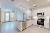This contemporary apartment, located at 9501 El Centro Dr in Dallas, TX, offers a well-designed living space of 760 square feet. The open floor plan seamlessly integrates the kitchen and living areas, creating an airy and spacious feel. The kitchen is a standout feature, boasting crisp white cabinetry, stainless steel appliances, and a subway tile backsplash. A central island with a built-in sink serves as both a functional workspace and a casual dining area.

The two bedrooms are generously sized, with the primary bedroom measuring 140 square feet. Both rooms feature plush carpeting and large windows that allow natural light to flood in. The two bathrooms are modern and well-appointed, with one showcasing a combination shower-tub and the other a walk-in shower. Both have sleek vanities and ample storage space.

Throughout the apartment, you'll find a neutral color palette and contemporary finishes, including light wood-look flooring in the main living areas. Ceiling fans in the bedrooms provide additional comfort. The apartment also includes a closet for extra storage. The overall design emphasizes functionality and style, making efficient use of the available space while maintaining a bright and inviting atmosphere.