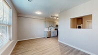 Located at 110 Cornell St in Kingston, NY, this efficiently designed single-floor unit offers a well-organized layout that maximizes every square foot. The combined kitchen and living area forms the heart of the space, highlighted by a sleek galley-style kitchen outfitted with light gray shaker cabinets, matte black hardware, stainless steel appliances — including a range, microwave, and refrigerator — a deep single-basin sink, and a clean subway tile backsplash. The open flow between the kitchen and living area creates a versatile, functional environment. Throughout the unit, light-toned luxury vinyl plank flooring adds warmth and continuity, while neutral-painted walls provide a bright, move-in-ready backdrop. Windows fitted with horizontal blinds bring in natural light and offer views of surrounding greenery and the neighborhood. The bathroom features a full tub-and-shower combination with white subway tile surround, continued matching flooring, and matte black fixtures that echo the unit's consistent modern aesthetic. A sliding barn door adds a stylish, space-conscious design touch to the hallway. The overall ambiance is clean, contemporary, and practical — ideal for those seeking a well-appointed, low-maintenance space in the heart of Kingston.