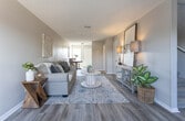 This two-story home offers a thoughtfully designed layout that balances comfort and functionality across both levels. The main floor welcomes you into a generously sized living room finished with light-toned hardwood-style flooring and a textured ceiling, creating a warm and inviting atmosphere. Large windows draw in natural light and provide views of the surrounding outdoor scenery. The living space flows seamlessly into a dedicated dining area and a galley-style kitchen, which features white cabinetry, gray countertops, black appliances, and matching hardwood-style floors — a clean, classic combination. A half bathroom on the main level adds everyday convenience.

Upstairs, the bedrooms are carpeted and well-proportioned, each offering natural light through multiple windows. The primary bedroom is a comfortable retreat, complete with a textured ceiling, plush carpeting, and direct access to the upper hallway. Additional bedrooms are versatile spaces, each featuring open closet storage and views of the outdoors. The upper level also provides access to a full bathroom. Throughout the home, a neutral color palette of warm beiges and soft grays creates a cohesive, move-in-ready aesthetic that is both modern and welcoming.