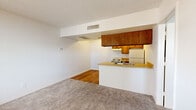 Located at 355 N Seventh St in Sierra Vista, Arizona, this one-bedroom, one-bathroom unit offers a well-organized single-floor layout designed for practical, everyday living. The open-concept main area seamlessly connects the kitchen and living room, creating a cohesive and functional shared space. The kitchen features warm wood cabinetry, a tile-effect laminate countertop peninsula with a double-basin sink, an electric range, and a full-size refrigerator. Hardwood flooring runs through the kitchen area, while plush carpet covers the living room and bedroom, adding warmth underfoot. The living room receives natural light through a window fitted with horizontal blinds, offering views of surrounding greenery. The bedroom is a comfortably sized retreat with carpet flooring, a window for natural light and ventilation, and direct access to a dedicated closet. The bathroom is clean and straightforward, featuring a full tub-shower combination with white tile surround, a vanity with storage, and hardwood flooring. Throughout the unit, textured ceilings and neutral white walls provide a bright, move-in-ready canvas. Central HVAC vents are present in the main living areas, ensuring year-round comfort in the Arizona climate.