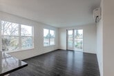 Located on Pacific Avenue in the heart of Santa Cruz, California, this well-appointed 2-bedroom, 2-bathroom residence offers a thoughtfully designed single-floor layout with clean, modern aesthetics throughout. Hardwood-style flooring flows seamlessly through every room, anchoring the bright, neutral palette of crisp white walls and recessed lighting.

The open-concept living area is spacious and airy, with large windows that invite ample natural light and views of the surrounding neighborhood. The kitchen is a standout feature, equipped with stainless steel appliances including a refrigerator, range, and over-the-range microwave, complemented by white cabinetry, dark countertops, and a window overlooking mature trees. Pendant lighting adds a modern touch above the kitchen counter.

The primary bedroom is generously sized and includes a wall-mounted mini-split unit for climate control, as well as access to a private outdoor area with scenic views. Additional bedrooms offer clean, open layouts with ample wall space. Three closets, including a spacious walk-in with wrap-around shelving, provide excellent storage throughout.

Both bathrooms feature white cabinetry with dark countertops and hardwood-style flooring. The full bath includes a soaking tub with shower, while the second bath offers a single vanity with a large mirror. Three hallways ensure smooth connectivity across the floor plan.