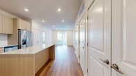 This well-appointed 2-bedroom, 2-bathroom residence offers a thoughtfully designed single-floor layout with a clean, contemporary aesthetic. Warm hardwood-style flooring flows seamlessly throughout the entire space, creating a cohesive and inviting atmosphere.

The open-concept kitchen serves as a central hub, featuring light wood cabinetry, granite-topped countertops, stainless steel appliances including a French door refrigerator, electric range, and built-in microwave, along with a central island that provides additional prep space and casual seating.

The kitchen opens directly into the living area, which benefits from large sliding glass doors that invite natural light and offer outdoor views of surrounding greenery. The bedrooms are bright and generously sized, each with large windows — one bedroom features a ceiling fan and a view of the exterior, while the primary bedroom includes direct sliding door access to an outdoor area. Both bedrooms are well-served by the seven closets distributed throughout the unit, offering exceptional storage capacity.

The bathrooms are finished with modern floating vanities, granite countertops, large mirrors, and tiled soaking tubs. A dedicated laundry area and a connecting hallway complete the functional layout, making this a practical and stylish living space.