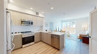 Located at 988 S Manhattan Pl in Los Angeles, this modern 2-bedroom, 2-bathroom residence offers a thoughtfully designed single-floor layout with clean, contemporary finishes throughout. Light-toned wood-style flooring flows seamlessly across the open-concept living and kitchen areas, creating a cohesive and inviting atmosphere.

The kitchen is a standout feature, outfitted with flat-front light wood cabinetry, white quartz countertops, a full suite of stainless steel appliances including a gas range, built-in microwave, dishwasher, and French door refrigerator. A peninsula with seating connects the kitchen to the living area, making it ideal for casual dining and entertaining. Large windows in the living room flood the space with natural light and offer urban views.

Both bedrooms are comfortably sized, with the primary bedroom featuring its own dedicated closet with built-in shelving and hanging rods. The second bedroom also benefits from a well-organized walk-in closet system. Each bathroom is finished with clean white tile, with one bathroom featuring a full soaking tub and shower combo set against marble-style flooring. The unit also includes an in-unit laundry area, adding everyday convenience to this well-appointed Los Angeles residence.
