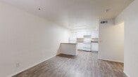 Located at 4415 S 28th St in Phoenix, AZ, this one-bedroom, one-bathroom unit offers a practical and efficient single-floor layout. Wood-look flooring runs throughout the entire space, providing a cohesive and easy-to-maintain surface in every room.

The combined kitchen and living area forms the heart of the unit. The kitchen is well-appointed with white shaker-style cabinetry extending to the upper walls, laminate countertops, a full suite of white appliances including a refrigerator and electric range, and a built-in range hood. A peninsula breakfast bar separates the kitchen from the living area, adding both counter space and a casual dining option. The living area offers a clean, open feel with a front entry door and an adjacent window fitted with vertical blinds.

The bedroom is a comfortable, dedicated space featuring a window for natural light, a sliding glass door with vertical blinds, and direct access to a closet. A hallway connects the bedroom to the rest of the unit and leads to the full bathroom, which includes a combined tub and shower, toilet, and wood-look flooring. The clean, neutral color palette of white walls and warm flooring tones creates a bright and functional living environment throughout.