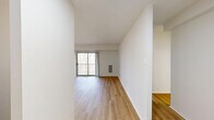 Located at 5764 Stevens Forest Rd in Columbia, MD, this 2-bedroom, 2-bathroom home offers a well-designed single-floor layout with a clean, modern aesthetic throughout. The open living room is a standout feature, showcasing light-toned hardwood-style flooring, a ceiling fan, and large sliding glass doors that lead to a private balcony, filling the space with natural light and offering views of the surrounding trees. The kitchen is thoughtfully appointed with white cabinetry, granite-style countertops, a stainless steel gas range, a stainless steel refrigerator, and a subway tile backsplash, with direct access to the living area through an arched passageway. The spacious primary bedroom features plush wall-to-wall carpeting, a generous built-in closet with louvered doors, and an en-suite vanity area with a round mirror. The second bedroom is equally comfortable, with carpet flooring and a bright window. Both bathrooms are finished in a clean, minimal style — one featuring a full tub-shower combination with tile surround and black accent hardware, and the other with light wood-style flooring, a white vanity, and matching black hardware accents. A hallway and closet provide additional storage and connectivity throughout the home.