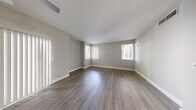 Located at 2750 W Wigwam Ave in Las Vegas, NV, this one-bedroom, one-bathroom unit offers a well-designed single-floor layout with a clean, modern aesthetic throughout. The open living area is finished with rich, dark wood-look flooring and neutral gray walls, complemented by multiple windows fitted with horizontal blinds that allow ample natural light to fill the space. The kitchen is well-appointed with white shaker-style cabinetry, white quartz countertops, a stainless steel undermount sink, and a full suite of stainless steel appliances including a gas range, over-the-range microwave, refrigerator, and dishwasher. Light wood-look flooring in the kitchen adds a warm contrast to the crisp cabinetry. The bedroom is a comfortable size, featuring the same dark hardwood-style flooring, a window with natural light, and direct access to a dedicated closet. The bathroom includes a full tub-shower combo with tile surround, a vanity with storage, and coordinating light wood-look flooring. A dedicated laundry area with a top-load washer and overhead wire shelving provides added convenience. The unit's consistent finishes and thoughtful layout make it a practical and attractive living space.
