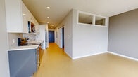 Located at 121 N 2nd St in Philadelphia's historic Old City neighborhood, this 560 square foot, one-bedroom, one-bathroom apartment offers a well-organized single-floor layout. The space includes a hallway, bedroom, closet, and bathroom, all finished in a clean, contemporary style. Light wood-tone flooring runs throughout the living areas and bedroom, complementing the neutral gray wall tones and crisp white trim. The main living area is open and bright, featuring large windows that invite natural light and offer views of the surrounding cityscape. Interior clerestory windows allow borrowed light between spaces, enhancing the unit's airy feel. The bedroom spans 120 square feet and includes built-in gray cabinetry, adding practical storage. The bathroom is finished with large-format dark gray tile flooring, a white soaking tub and shower combination, a sleek vanity with dark cabinetry and brushed nickel hardware, and recessed lighting. A dedicated closet provides additional storage. The unit's modern, minimalist aesthetic is consistent throughout, making it a functional and stylish urban residence in one of Philadelphia's most walkable and historically rich neighborhoods.