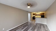Located at 26 Arbor Village Ct in Ferguson, MO, this one-bedroom, one-bathroom unit offers a thoughtfully laid-out single-floor plan. The open-concept living and kitchen area serves as the heart of the home, unified by durable vinyl plank flooring in a warm gray tone that extends throughout the entire unit. The living room is well-lit and airy, featuring a ceiling fan with light, neutral taupe walls, and a sliding glass door that invites natural light and provides direct access to the outdoors. The kitchen is efficiently designed with rich dark wood cabinetry, a stainless steel sink, a breakfast bar with a dark countertop, and black appliances including a gas range and refrigerator. A track lighting fixture overhead provides ample task lighting. The spacious bedroom includes a ceiling fan, a natural light-admitting window, and a double-door closet offering generous storage. The bathroom is cleanly appointed with a white vanity and countertop, a full tub-shower combination, wood-look flooring, and a skylight for added brightness. A dedicated hallway connects the bedroom and bathroom, completing this efficiently organized and move-in ready home.