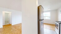 Located at 1050 Castlefield Ave, Unit 105, this well-appointed one-bedroom, one-bathroom unit offers a thoughtfully laid out single-floor plan. The living area is bright and open, showcasing classic parquet wood flooring in a basket-weave pattern and a large window that invites natural light while framing outdoor views. A radiator beneath the window provides reliable, traditional heating throughout the space.

The kitchen is a standout feature, designed in a galley style with white cabinetry extending to the ceiling, dark countertops, and a white subway tile backsplash. It is fully equipped with stainless steel appliances, including a refrigerator, electric range, and built-in microwave, complemented by marble-style flooring that ties the clean aesthetic together.

The bedroom is a comfortable size, continuing the parquet flooring found throughout the unit, and includes a built-in sliding door closet for ample storage. A window with an outdoor view and a radiator beneath it mirror the inviting feel of the living area.

The bathroom features classic white square wall tiles, a combined bathtub and shower with a curved curtain rod, a pedestal sink, and marble-style floor tiles, creating a clean and timeless finish. A hallway connects the rooms, completing this functional and well-designed unit.