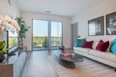 Located at 1 Buttonwood Ct in Madison, WI, this thoughtfully designed 2-bedroom, 3-bathroom residence offers a clean, contemporary aesthetic throughout its single-level floor plan. The open-concept kitchen and living area serves as the heart of the home, featuring a sleek kitchen outfitted with white cabinetry, stainless steel appliances — including a refrigerator, range, microwave, and dishwasher — a tiled backsplash, and a peninsula with bar seating. Light wood-style flooring flows seamlessly into the living room, which is bathed in natural light and provides direct access to a private balcony overlooking open green space and tree-lined surroundings. The two bedrooms are comfortably sized, with the primary bedroom offering its own dedicated space and generous closet access — six closets are distributed throughout the unit. Three full bathrooms with white vanities and modern finishes serve the residence. A well-lit hallway connects the private quarters, with wall art niches adding a decorative touch. The neutral color palette, recessed lighting, and clean lines throughout create a bright, contemporary ambiance well-suited for modern living in the Madison area.