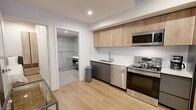 This 600 square foot apartment, located at #532 TENTEN Downtown, showcases a contemporary design that maximizes space efficiency. The open-plan layout seamlessly integrates living areas, creating a sense of spaciousness. The kitchen is a standout feature, boasting modern stainless steel appliances, light wood cabinetry, and a clean white backsplash. Industrial-inspired elements, such as exposed concrete ceilings and pillars, add character to the space.

The bedroom area, while compact, offers ample storage with a built-in closet system. The bathroom continues the modern aesthetic with a glass-enclosed shower, floating vanity, and LED-backlit mirror. Light wood flooring throughout enhances the bright, airy feel of the apartment.

Notable features include a balcony with metal railings, providing outdoor space and natural light. The building itself appears to have a unique architectural design with arched openings and multiple balconies, suggesting a vibrant urban setting.

This apartment efficiently utilizes its 600 square feet, offering a stylish and functional living space ideal for urban dwellers seeking a contemporary home in a downtown location.