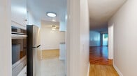 Located in the desirable Beverly Grove neighborhood of Los Angeles, this one-bedroom, one-bathroom unit offers a well-organized layout across a single floor. The open-concept living and dining area is a highlight, featuring warm-toned hardwood flooring that extends throughout most of the space, crisp white walls, and a sliding glass door that leads to a private balcony with views of mature surrounding greenery — filling the room with natural light.

The galley-style kitchen is efficiently designed with white cabinetry, granite-style countertops, a decorative tile backsplash, tile flooring, and stainless steel appliances including a full-size refrigerator. A pass-through opening connects the kitchen to the dining area, enhancing the flow of the space.

The bedroom is a comfortable, well-proportioned retreat with the same warm hardwood flooring, a window providing natural light, and a mirrored sliding-door closet. Additional closet storage is found throughout the hallways, providing generous organization options.

The bathroom features a glass-enclosed stand-up shower, a white vanity with a granite-style countertop, tile flooring, and clean, bright finishes throughout. The overall ambiance of this home is light, clean, and functional — well-suited for comfortable city living.
