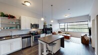 Located at 166 Concord Exchange N in South Saint Paul, Minnesota, this single-floor residence offers a thoughtfully designed open-concept layout with modern finishes and a bright, contemporary ambiance. The kitchen serves as a central hub of the living space, outfitted with stainless steel appliances, white shaker-style cabinetry, a herringbone tile backsplash, and dark countertops. A freestanding island with a stone-patterned surface and bar seating provides additional workspace and casual dining. Pendant lighting overhead adds a refined touch, while durable wood-look flooring extends throughout the main living areas.

The kitchen flows seamlessly into the living room, which is highlighted by a large bank of windows that invite generous natural light and provide outdoor views. The elevated ceilings contribute to an open, airy feel throughout the space.

Two bedrooms offer comfortable retreats, each featuring carpeted floors, windows with outdoor views, and ample room for furnishings. The bathroom is finished with white cabinetry, a single vanity, and a tub-shower combination with wood-look flooring that echoes the main living area. Overall, the unit presents a clean, modern aesthetic with functional design elements throughout.
