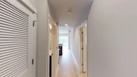 Located at 4525 Guadalupe St in Austin, Texas, this single-floor space offers a clean, modern aesthetic defined by crisp white walls, light wood flooring, and an efficient, well-organized layout. A central hallway serves as the spine of the space, connecting the various rooms with a sense of flow and openness. Recessed lighting overhead and natural light filtering in from windows keep the interiors bright and welcoming throughout.

The layout reveals a thoughtfully arranged floor plan visible from the overhead view, with distinct zones for living, working, and utility functions. The living area is generously proportioned, featuring the warm light wood flooring that carries through much of the space. A compact kitchen area includes dark appliances and counter space, positioned to take advantage of natural light from a nearby window.

Additional rooms branch off the central corridor, offering private spaces that maintain the same consistent palette of neutral tones and light finishes. The bathroom is neatly tucked into the layout, and a ceiling fan in one of the rooms adds both function and comfort. Throughout the space, the design emphasizes simplicity and practicality, with white trim, recessed lighting, and minimalist finishes contributing to an overall atmosphere that is bright, clean, and move-in ready.
