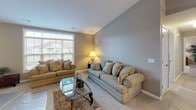 Located on Hermitage Hills Blvd in Hermitage, PA, this well-appointed single-floor home offers a thoughtfully designed layout with a cohesive neutral palette throughout. The kitchen is a standout feature, showcasing crisp white cabinetry, granite countertops, a large island with a built-in sink, and a full suite of stainless steel appliances, all complemented by light hardwood-style flooring and a ceiling fan overhead. Adjacent to the kitchen, the dining area features vaulted ceilings, elegant hardwood-style flooring, a decorative chandelier, and framed wall art, creating an inviting setting for meals. The living room offers generous natural light through oversized windows with views of the surrounding neighborhood and plush carpeting underfoot. The primary bedroom is spacious and comfortable, fitted with ceiling fan lighting and a window that brings in natural light. A second bedroom provides a cozy retreat with its own ceiling fan. A dedicated office or flex room features multiple windows and soft carpet, ideal for work or relaxation. The bathroom is finished with marble-style tile flooring, a white vanity, and a tub-shower combination. The attached two-car garage offers ample storage and parking space with an automatic opener system.