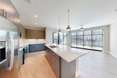 Located at 2801 Windy Ridge Pky SE in Atlanta, GA, this modern 3-bedroom, 2-bathroom single-floor residence offers a thoughtfully designed open-concept layout. The combined dining, kitchen, and living area serves as the heart of the home, bathed in abundant natural light through dramatic floor-to-ceiling windows that frame views of the surrounding cityscape. Light wood-look flooring flows seamlessly throughout the main living areas, enhancing the bright and airy ambiance.

The contemporary kitchen is a standout feature, showcasing a large center island with a quartz countertop and undermount sink, stylish pendant lighting, two-tone cabinetry with slate-blue lower cabinets and wood-grain upper cabinets, a classic white subway tile backsplash, and stainless steel appliances. Sliding glass doors lead directly to a private balcony, further extending the living space outdoors.

The three bedrooms are well-proportioned, with plush carpeting, ceiling fans, and ample closet space — including a generously sized walk-in closet with built-in wire shelving in the primary suite. The two bathrooms are finished with clean, modern fixtures, a floating vanity with quartz countertops, and wood-look flooring. A dedicated laundry area and four closets throughout round out this well-appointed residence.