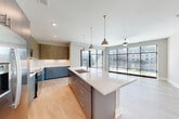 Located at 2801 Windy Ridge Pky SE in Atlanta, GA, this modern 3-bedroom, 2-bathroom single-floor residence offers a thoughtfully designed open-concept layout. The combined dining, kitchen, and living area serves as the heart of the home, bathed in abundant natural light through dramatic floor-to-ceiling windows that frame views of the surrounding cityscape. Light wood-look flooring flows seamlessly throughout the main living areas, enhancing the bright and airy ambiance.

The contemporary kitchen is a standout feature, showcasing a large center island with a quartz countertop and undermount sink, stylish pendant lighting, two-tone cabinetry with slate-blue lower cabinets and wood-grain upper cabinets, a classic white subway tile backsplash, and stainless steel appliances. Sliding glass doors lead directly to a private balcony, further extending the living space outdoors.

The three bedrooms are well-proportioned, with plush carpeting, ceiling fans, and ample closet space — including a generously sized walk-in closet with built-in wire shelving in the primary suite. The two bathrooms are finished with clean, modern fixtures, a floating vanity with quartz countertops, and wood-look flooring. A dedicated laundry area and four closets throughout round out this well-appointed residence.