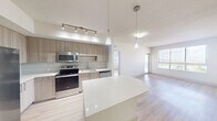 Located at 805 North Olive Avenue in West Palm Beach, FL, this single-floor, 3-bedroom, 2-bathroom unit offers a well-designed layout that maximizes functionality and comfort. Light wood-style flooring flows throughout the space, complementing a bright, neutral color palette.

The open-concept kitchen is a standout feature, equipped with stainless steel appliances including a side-by-side refrigerator, electric range, built-in microwave, and dishwasher. Warm-toned wood cabinetry, a mosaic tile backsplash, white quartz countertops, and a central island with pendant lighting create a stylish and practical cooking environment. Track lighting adds focused illumination above the workspace.

The kitchen opens seamlessly into the living room, which benefits from large windows that invite abundant natural light and offer views of the surrounding West Palm Beach cityscape. The bedrooms are quietly situated and feature light wood-style flooring, ceiling fans, and windows with exterior views. The spacious primary bedroom includes a dedicated closet with wire shelving for organized storage.

The bathrooms are finished with large-format tile flooring, wood-toned vanities with white countertops, and a glass-enclosed walk-in shower with built-in shelving. A hallway connects the living areas to the bedrooms, with additional closet storage available throughout. The overall design is clean, modern, and move-in ready.