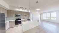 Located at 805 North Olive Avenue in West Palm Beach, FL, this single-floor, 3-bedroom, 2-bathroom unit offers a well-designed layout that maximizes functionality and comfort. Light wood-style flooring flows throughout the space, complementing a bright, neutral color palette.

The open-concept kitchen is a standout feature, equipped with stainless steel appliances including a side-by-side refrigerator, electric range, built-in microwave, and dishwasher. Warm-toned wood cabinetry, a mosaic tile backsplash, white quartz countertops, and a central island with pendant lighting create a stylish and practical cooking environment. Track lighting adds focused illumination above the workspace.

The kitchen opens seamlessly into the living room, which benefits from large windows that invite abundant natural light and offer views of the surrounding West Palm Beach cityscape. The bedrooms are quietly situated and feature light wood-style flooring, ceiling fans, and windows with exterior views. The spacious primary bedroom includes a dedicated closet with wire shelving for organized storage.

The bathrooms are finished with large-format tile flooring, wood-toned vanities with white countertops, and a glass-enclosed walk-in shower with built-in shelving. A hallway connects the living areas to the bedrooms, with additional closet storage available throughout. The overall design is clean, modern, and move-in ready.