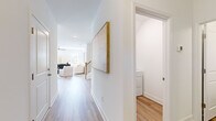 This two-story home is thoughtfully designed with a bright, neutral palette and light wood flooring throughout the main level, creating a clean and welcoming atmosphere. The main floor hosts the primary living areas, including an open living room fitted with a ceiling fan and multiple windows that invite abundant natural light. Adjacent to it, a dedicated dining area provides a comfortable space for meals, also benefiting from natural light. The kitchen is well-equipped with white shaker cabinetry, subway tile backsplash, light countertops, and a full suite of stainless steel appliances. A dedicated laundry room with a full-size washer and dryer adds everyday convenience on this level. A hallway connects the main living areas, with a staircase leading to the upper floor. Upstairs, the spacious primary bedroom features vaulted ceilings, plush carpet, and a walk-in closet with wire shelving, alongside a private en-suite bathroom with a double vanity, wood-look tile flooring, and a glass-enclosed shower. Two additional bedrooms each include closet storage and natural light from windows. With three full bathrooms, dedicated storage, and a functional layout across two floors, this home offers comfort and practicality throughout.