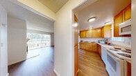 Located in Redmond, WA, this two-story, 3-bedroom, 2-bathroom home offers a practical and comfortable layout spread across two well-proportioned floors. The main level features an open-concept living room and kitchen area, where hardwood-style flooring flows throughout. The living room is a welcoming space anchored by a tile-surround fireplace with a classic white mantle, complemented by large sliding glass doors fitted with vertical blinds that open to a balcony, filling the room with natural light and providing pleasant outdoor views of the surrounding greenery. The kitchen is well-appointed with warm honey-toned cabinetry, ample counter space, and white appliances including a refrigerator, range, dishwasher, and microwave, all illuminated by a window overlooking the outdoors. Upstairs, three carpeted bedrooms offer a quiet retreat, each with windows that invite natural light. The primary bedroom includes a mirrored sliding-door closet with built-in shelving. The two bathrooms are functionally designed, one featuring a full tub-shower combination with a window, and the other a half bath. Textured ceilings are present throughout, adding a consistent architectural detail to the home's overall clean and neutral aesthetic.