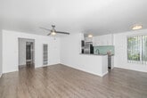 Located at 202 Fourth Ave in the sought-after Venice neighborhood of Los Angeles, this 2-bedroom, 2-bathroom single-floor residence offers a clean, modern aesthetic throughout. Light wood laminate flooring flows consistently across the living areas and bedrooms, creating a cohesive and airy feel.

The open living room is a standout, featuring a ceiling fan with integrated lighting, bright white walls, and a sliding glass door flanked by vertical blinds that flood the space with natural light and provide access to outdoor greenery. A pass-through counter connects the living area to the kitchen, enhancing the open feel.

The kitchen is well-appointed with white shaker-style cabinetry, stainless steel appliances including a dishwasher and refrigerator, a modern faucet, and a distinctive mint-green subway tile backsplash that adds a touch of character.

Both bedrooms are generously sized, with the primary bedroom offering notable square footage, vertical-blind windows for natural light, and dedicated closet space. Additional closets are found throughout, providing ample storage.

The two bathrooms are finished with floor-to-ceiling textured tile in warm brown tones, glass-enclosed tub-shower combinations, and clean white fixtures, delivering a polished, updated look. Three hallways connect the layout efficiently, rounding out this well-organized and stylish residence.