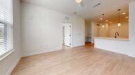 This 670-square-foot, one-bedroom, one-bathroom apartment in North Augusta, SC, delivers a clean, modern aesthetic throughout its single-floor layout. Light-toned luxury vinyl plank flooring flows seamlessly across every room, complementing the crisp white walls and bright, airy atmosphere.

The open-concept kitchen and living area form the heart of the unit. The kitchen is outfitted with full-height white shaker cabinets, a white subway tile backsplash, stainless steel appliances including a side-by-side refrigerator, electric range, and over-the-range microwave, plus a single-basin sink with a matte black faucet and pendant lighting overhead. A louvered utility closet is conveniently situated nearby.

The living room offers generous space with ceiling fan, recessed lighting, and ample wall outlets. The 140-square-foot primary bedroom features two large windows with blinds that invite natural light and outdoor views, along with a ceiling fan for added comfort. A dedicated walk-in closet with built-in shelving and rod systems provides excellent storage.

The bathroom is finished with a white vanity featuring matte black hardware, a tiled tub-surround shower, and wood-look flooring, maintaining the cohesive modern design found throughout the entire unit.