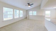 This two-story, 1-bedroom, 1-bathroom unit at 5201 S County Line Rd in Oklahoma City, OK spans 750 square feet across two floors. The ground level (70 sq ft) features an attached garage with a standard roll-up door and an adjacent hallway, providing convenient interior access. The main living area (690 sq ft) is located on the upper floor, accessible via a staircase. The open-concept layout connects a bright living room and kitchen, with large windows allowing abundant natural light and outdoor views. The living area features plush carpet flooring and a ceiling fan. The kitchen is equipped with stainless steel appliances—including a refrigerator, electric range, and over-the-range microwave—complemented by white shaker-style cabinetry, granite-style countertops, and durable wood-look vinyl flooring. The primary bedroom measures 160 square feet, features carpet flooring, a ceiling fan, and a window, with access to a spacious walk-in closet outfitted with a full-width hanging rod. The bathroom includes a vanity with granite-style countertops, white cabinetry, wood-look vinyl flooring, and a full tub/shower combo. The unit offers a clean, neutral aesthetic throughout.