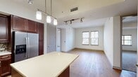 This contemporary 990 square foot apartment offers a harmonious blend of style and functionality. The open-concept layout seamlessly integrates the living room and gourmet kitchen, creating an inviting space for both relaxation and entertainment. The kitchen boasts rich wood cabinetry, stainless steel appliances, and a convenient center island, all enhanced by modern lighting fixtures.

The apartment features two bedrooms, including a spacious 200 square foot primary bedroom, which likely includes an en-suite bathroom. In total, there are three well-appointed bathrooms, finished with elegant tile work and modern fixtures. Two closets provide ample storage space, with one featuring a custom shelving system for optimal organization.

Throughout the apartment, you'll find a mix of warm wood flooring and plush carpeting, creating a cozy yet sophisticated ambiance. Large windows in the bedrooms and living areas allow for abundant natural light, while offering the option of privacy with built-in blinds. The apartment also includes modern amenities such as ceiling fans and recessed lighting.

The thoughtful design maximizes the use of space, making this apartment feel larger than its actual square footage. Whether you're looking for a comfortable living space or an stylish urban retreat, this apartment offers the perfect balance of modern design and practical living.
