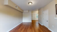 Located at 1951 Milton Rd in Charlotte, NC, this two-story home offers a practical and well-maintained layout across two levels. The main floor greets visitors with a bright entryway featuring a front door flanked by a window that brings in natural light, complemented by warm hardwood flooring that extends throughout the living and common areas. An open living space flows toward the rear of the home, where a dedicated staircase with elegant wrought iron railings leads to the upper level. The kitchen is well-appointed with rich wood cabinetry, granite-style countertops, a double sink, and black appliances including a refrigerator and electric range, all set atop hardwood flooring with a window providing natural light. The upper floor features carpeted bedrooms, each offering a comfortable, quiet setting with windows that frame views of the surrounding greenery. A full bathroom on the upper level includes a tub-shower combination with white tile surround, a wood vanity, and hardwood flooring, with a window adding ventilation and natural light. Throughout the home, neutral wall tones, clean white trim, and consistent finishes create a cohesive and inviting atmosphere suited for everyday living.