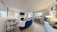Located at 5264 Tamarus St in Las Vegas, NV, this single-floor, 2-bedroom, 2-bathroom home offers a thoughtfully designed open layout across a comfortable footprint. The combined living and kitchen area serves as the heart of the home, where light wood-look flooring, a textured ceiling, and a white brick fireplace create a warm and inviting atmosphere. A distinctive arched pass-through connects the living area to the kitchen, which features white shaker cabinetry, granite countertops, a gray subway tile backsplash, stainless steel appliances, and a skylight that fills the space with natural light. The adjacent dining room offers direct access to the outdoors through a large window and door, enhancing the sense of openness. The spacious primary bedroom includes multiple windows for ample natural light, while its en-suite bathroom is highlighted by a large soaking tub, a full-width mirror, and granite vanity surfaces. The second bathroom features a walk-in shower, dual undermount sinks, white cabinetry, and granite countertops. A connecting hallway with access to two closets provides practical storage throughout. The home's cohesive neutral palette and wood-look flooring lend a clean, modern feel to every room.