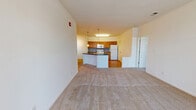 Located at 610 Towne Center Dr in Joppa, MD, this single-floor residence offers three bedrooms and two bathrooms within a thoughtfully designed layout. The open-concept living and kitchen area serves as the heart of the home, where warm-toned hardwood-style flooring in the kitchen transitions seamlessly into plush carpeting in the living room. The kitchen is outfitted with honey-toned wood cabinetry, dark countertops, a tile backsplash, and white appliances including a gas range, built-in microwave, and refrigerator. A peninsula with pendant lighting and an integrated sink adds both functionality and a natural gathering point. Track lighting in the living area enhances the bright, neutral ambiance throughout. The spacious primary bedroom offers generous square footage with a window providing natural light. Additional bedrooms are carpeted with ample closet storage, including double-door closets. The bathrooms feature warm tile flooring, oak vanities, and a full tub-shower combo with white tile surround and a bright window. Clean white walls and consistent neutral finishes throughout the residence create a cohesive, move-in-ready atmosphere well suited for comfortable everyday living.