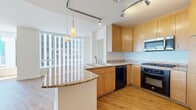 Located in the heart of downtown Phoenix, this well-appointed residence offers a thoughtfully designed layout spanning a single floor with 1 bedroom, 2 bathrooms, and multiple living areas. Light hardwood flooring runs throughout, lending warmth and continuity to each room.

The open-concept living and kitchen area is a standout feature, anchored by floor-to-ceiling windows that flood the space with natural light and frame impressive city skyline views. The kitchen is equipped with warm wood cabinetry, granite countertops, a curved breakfast bar with pendant lighting, stainless steel appliances including a gas range, built-in microwave, and dishwasher — all complemented by track lighting overhead.

The spacious bedroom connects to a walk-in closet with built-in shelving, offering practical storage. Two full bathrooms include one featuring a glass-enclosed shower, wood-toned vanity with granite countertops, and a stacked in-unit washer and dryer — a convenient and functional addition.

Two distinct living areas provide flexibility for lounging or dining, while a hallway and additional closet further enhance storage options. Clean white walls, recessed lighting, and an open floor plan create a bright, modern ambiance suited for urban living in the heart of Phoenix.