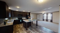 Located at 4001 E 134th St in Chicago, IL, this single-story home offers a functional and well-appointed layout. The kitchen serves as a central highlight, featuring rich dark cabinetry, light marble-look countertops, a textured tile backsplash, recessed lighting, and a full suite of black appliances including a gas range, microwave, and refrigerator. A kitchen island with matching countertop provides additional prep space and casual seating. Wood-look flooring runs throughout the kitchen and dining area, adding warmth and durability. The open layout allows the kitchen to flow naturally into the living area, which is finished with plush carpeting, a ceiling fan, and windows dressed with curtain panels that allow for natural light. The bedrooms are carpeted and feature neutral wall panels with dark trim accents, blinds-covered windows, and overhead lighting, offering comfortable and functional spaces. The home includes at least two bathrooms, each equipped with a tub-shower combination, vanity with granite-look countertop, and a large mirror. Textured ceilings are found throughout the home, contributing to its consistent interior style. The floor plan provides a practical and comfortable living environment suited for everyday use.