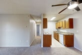 Located at 12693 E Kansas Dr in Aurora, CO, this single-floor, 2-bedroom, 1-bathroom unit offers a practical and comfortable layout. The open-concept living room and kitchen area anchors the home, with the living room featuring plush carpeting, a ceiling fan, and a sliding glass door that invites natural light and provides outdoor access. The galley-style kitchen is efficiently designed with warm wood cabinetry, granite-look countertops, tile flooring, and white appliances including a range, microwave, refrigerator, and dishwasher — all illuminated by a skylight-style overhead fixture.

The two bedrooms are carpeted and well-sized, with the primary bedroom offering generous square footage. Both rooms feature neutral wall tones and textured ceilings. The full bathroom is finished with tile flooring and a tiled tub-shower surround with chrome fixtures. A dedicated laundry room with tile flooring accommodates a full-size washer and dryer side by side, adding everyday convenience. A hallway closet provides additional storage. The unit's neutral palette and functional layout make it a practical living space in the Aurora community.