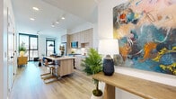 Located at 802 N 1st Ave in downtown Phoenix, this thoughtfully designed one-bedroom, one-bathroom residence offers a clean, contemporary aesthetic throughout its efficiently arranged single-floor layout. The open-concept living area seamlessly connects the kitchen, dining, and living spaces, creating an airy and functional environment. The kitchen is outfitted with light wood cabinetry, stainless steel appliances including a gas range, French door refrigerator, and dishwasher, complemented by white subway tile backsplash and a movable island that doubles as a dining surface. Wide-plank light wood flooring runs throughout the main living areas, enhancing the bright, modern atmosphere. The living room is anchored by floor-to-ceiling black-framed windows and a glass door that opens to a private patio, offering open views of the Phoenix skyline. The bedroom features plush carpeting, a tall window with outdoor views, and direct access to a dedicated walk-in closet. The bathroom is finished with crisp white tile, a wood-toned floating vanity, a large mirror, and a glass-enclosed shower. An in-unit laundry area and a welcoming entrance complete this well-appointed residence.