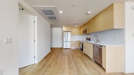 Located on the penthouse level at 7050 Hawthorn Ave in Hollywood, Los Angeles, this 3-bedroom, 3-bathroom residence offers a thoughtfully designed open-concept layout with contemporary finishes throughout. Light wood-tone flooring flows seamlessly across the entire unit, creating a warm yet modern aesthetic.

The kitchen is a standout feature, outfitted with flat-front light wood cabinetry, a crisp tile backsplash, and a full suite of stainless steel appliances including a French door refrigerator, electric range, built-in microwave, and dishwasher. The kitchen opens directly into the combined dining and living area, making it ideal for entertaining.

The generously sized primary bedroom includes direct access to a private balcony with open city and hillside views, as well as a walk-in closet. Additional bedrooms are well-proportioned, each featuring mirrored sliding closets and large windows that invite abundant natural light and skyline views.

Each of the three bathrooms is finished with large-format stone-look tile in the showers, floating wood vanities with white countertops, and clean chrome fixtures. A dedicated laundry area and four closets throughout the unit provide ample storage. The overall ambiance is bright, clean, and modern, reflecting a refined urban lifestyle.