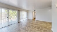 Located at 1715 Central Ave in Alameda, California, this two-bedroom, one-bathroom unit offers a well-organized single-floor layout with thoughtfully updated finishes throughout. Wood-look luxury vinyl flooring flows consistently across all living areas, lending a cohesive and contemporary feel to the space.

The open living and dining area is a standout feature, highlighted by a large sliding glass door dressed with vertical blinds that fills the room with natural light and provides outdoor views. A painted cinder block accent wall adds a subtle architectural character to this airy, open space.

The kitchen is outfitted with crisp white shaker cabinetry, granite-look countertops, and a full suite of stainless steel appliances including a range, over-the-range microwave, and refrigerator. A flush-mount ceiling light and wood-look flooring complete the clean, functional kitchen design.

Both bedrooms are comfortably sized, each featuring ceiling fans and natural light from windows. The primary bedroom includes mirrored sliding closet doors that enhance the sense of space, while additional closets throughout the unit provide ample storage.

The bathroom offers a double-sink vanity with matte black hardware, framed mirrors, tile flooring, and a glass-enclosed shower, delivering a polished, modern aesthetic. A utility room and hallway round out the practical layout of this well-appointed Alameda residence.