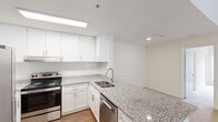 Located on Wesley Place in Lawrenceville, Georgia, this single-floor unit offers a clean, modern aesthetic with a thoughtfully designed layout. The kitchen serves as a central highlight, showcasing granite countertops, white shaker-style cabinetry, a subway tile backsplash, and stainless steel appliances including an electric range and dishwasher. A peninsula with an undermount sink provides additional prep space and opens toward the living area, which features neutral carpet flooring and an open, airy feel enhanced by natural light. The transition between the kitchen's hardwood-style flooring and the carpeted living and bedroom spaces creates a clear, functional delineation throughout the unit. The bedrooms are generously sized, carpeted, and bathed in natural light from large windows fitted with horizontal blinds. The bathrooms are well-appointed with granite-topped vanities, white cabinetry, and brushed nickel fixtures. One bathroom includes a shower-tub combination, while another features a single vanity with ample mirror space and stylish lighting. Crisp white walls and consistent finishes throughout lend the space a bright, cohesive character. The overall layout is efficient and practical, making excellent use of the available footprint while maintaining a comfortable, move-in-ready atmosphere.