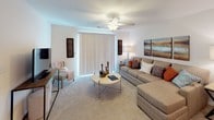 This single-story residence in Columbia, SC offers a thoughtfully designed layout with comfortable living spaces throughout. The living room is a welcoming retreat, featuring plush carpeting, a ceiling fan, and large sliding glass doors with vertical blinds that fill the room with natural light. Adjacent to the living room, the dining area is highlighted by an elegant chandelier and flows seamlessly into the kitchen, making it ideal for entertaining.

The kitchen is well-equipped, showcasing rich dark cabinetry, light countertops, and a full suite of black appliances including a range, microwave, and refrigerator, all set atop wood-look flooring. The U-shaped layout provides generous counter and storage space.

Both bedrooms are carpeted and feature ceiling fans, with natural light provided by windows with blinds. Each room offers a calm, restful atmosphere with ample space for furnishings. The two bathrooms are finished with matching dark wood vanities, light countertops, and wood-look flooring, each offering a tub-shower combination.

Completing the home is a dedicated laundry area housing a full-size washer and dryer with overhead shelving for added convenience. This residence combines practical functionality with a cohesive, neutral aesthetic throughout.
