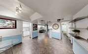 Located at 3710 Inverrary Dr in Lauderhill, FL, this single-floor residence offers a thoughtfully arranged layout comprising one bedroom, two bathrooms, a living room, dining room, kitchen, hallway, utility room, balcony, and three closets. Large-format tile flooring flows throughout the open main area, connecting the kitchen, dining, and living spaces seamlessly. The kitchen features stainless steel appliances, white cabinetry, a mosaic tile backsplash, and light stone countertops, delivering a clean and functional workspace. The living room is anchored by a ceiling fan and sliding glass doors that open to a private balcony with outdoor views, filling the space with natural light. Built-in shelving and a dedicated desk area provide a versatile workspace within the living room. The bedroom is comfortably sized, featuring a ceiling fan, natural light from a large window, recessed accent lighting, and ample closet storage. The two bathrooms offer distinct aesthetics: one is tiled in rich green marble-style tile with a tub-shower combo, while the second features bold, dark decorative wallpaper with an elegant pedestal sink. A dedicated utility room adds practical functionality to the overall layout.